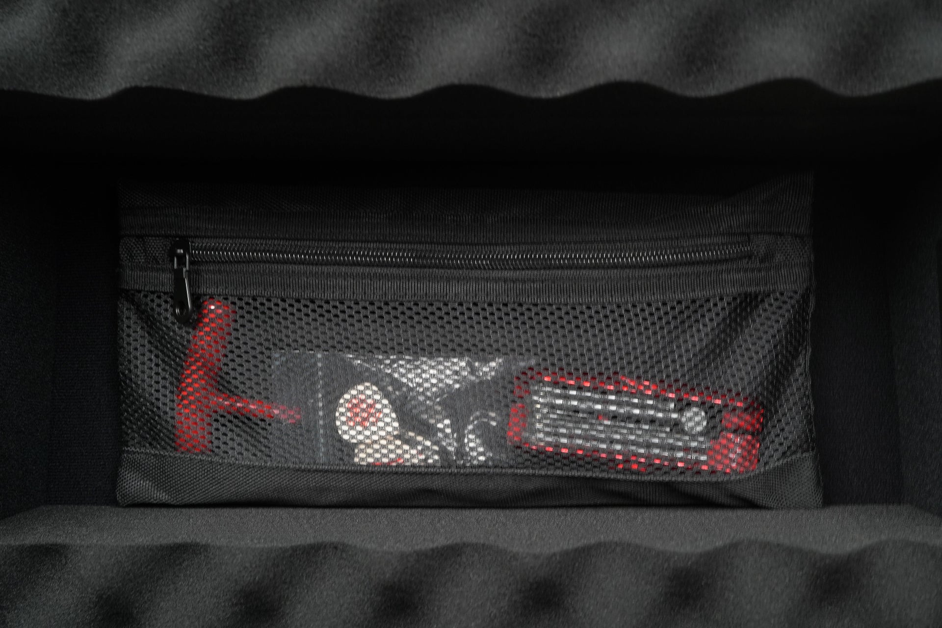 Black pouch with mesh pocket on a dark textured background
