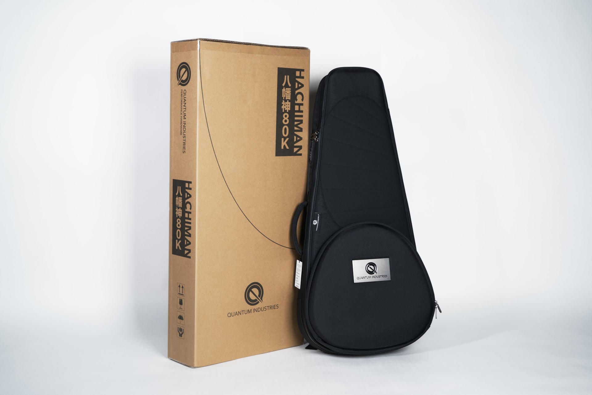 Black guitar case and cardboard box with 'Hachiman' branding on a white background